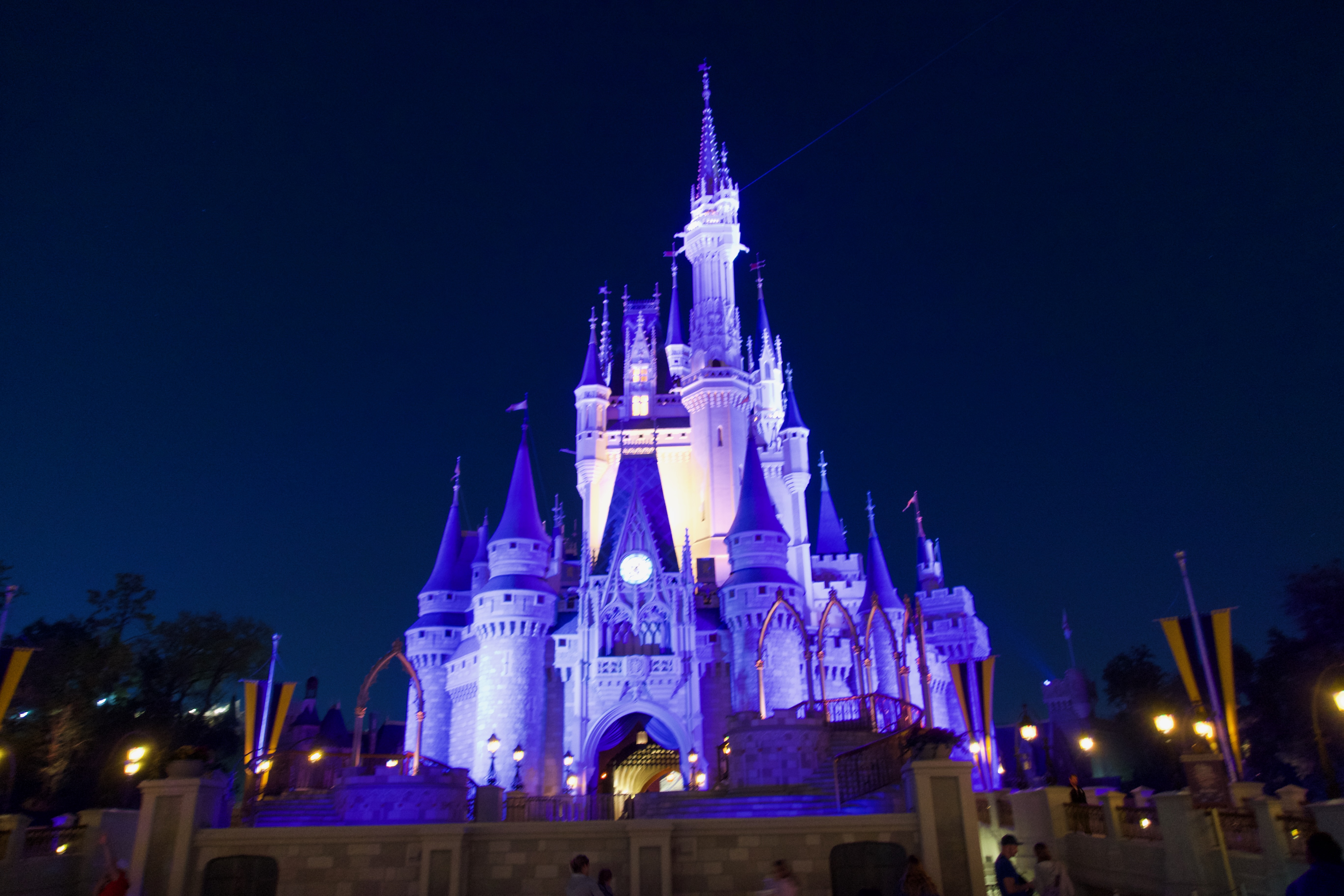 Magic Kingdom Cinderella Castle illuminated at night with stunning purple and blue lighting